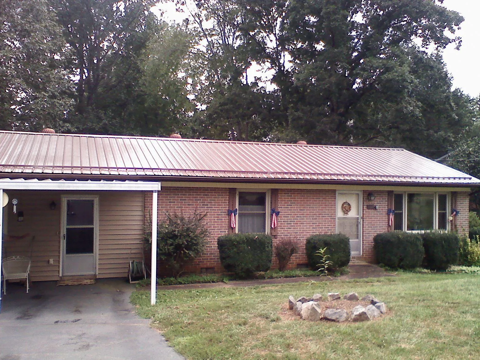 Bronze metal roof and carport on a brick ranch home — Roof Repair work by our crew in New Auburn